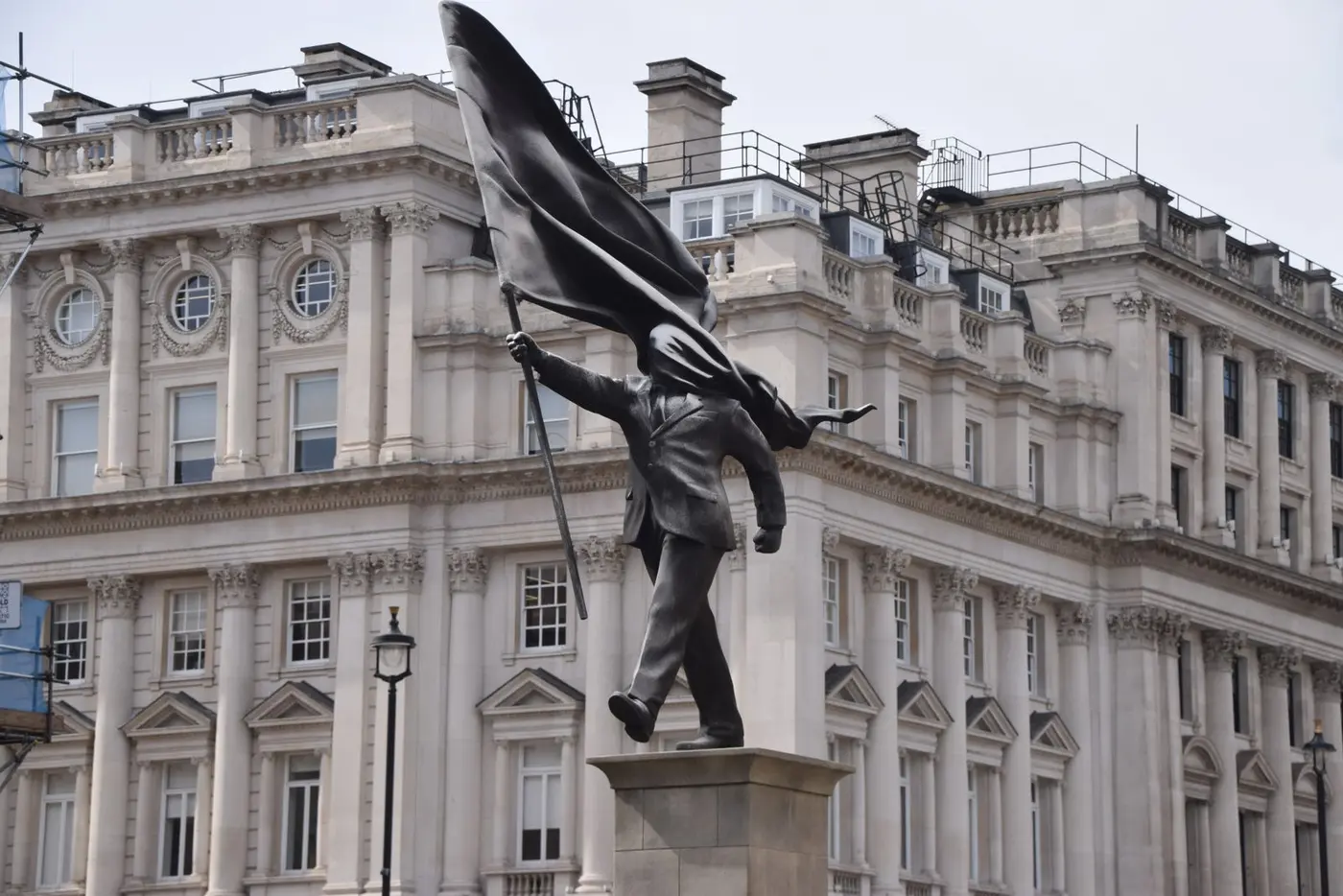 statue of a man blinded by a flag put up by banksy in central london