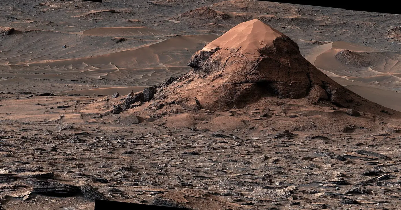 highres photo shows sandcapped butte rising from mars plain of polygons